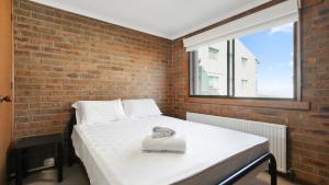 a bed in a room with a brick wall at Lawlers 17 in Mount Hotham