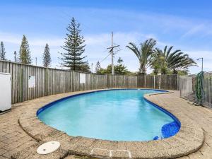 - une piscine dans une arrière-cour avec une clôture dans l'établissement Kawana Beachside Getaway 1 Bedroom Apartment, à Buddina