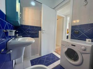a bathroom with a sink and a washing machine at Casa Riviera in San Vito lo Capo