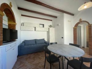 un soggiorno con divano blu e tavolo di Casa Riviera a San Vito lo Capo