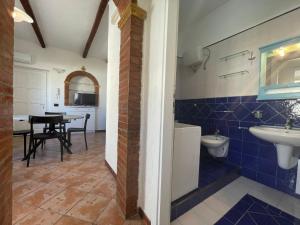 a bathroom with a sink and a toilet and a table at Casa Riviera in San Vito lo Capo