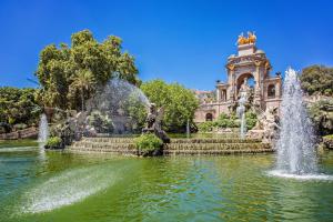 a fountain in a pond in front of a building at Sweet Inn - Park Mediterranean in Barcelona