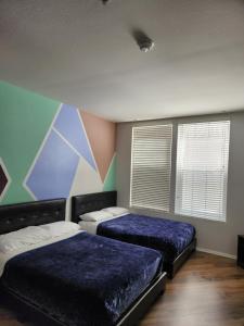 a bedroom with two beds and a mural on the wall at MARINA DEL REY BEAUTY in Los Angeles