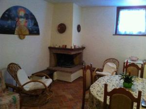 a living room with a fireplace and a table and chairs at Ospitaci Appartamenti di campagna Le Rancole in Valtopina