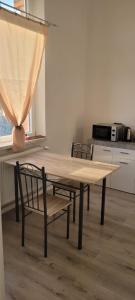 einen Holztisch und zwei Stühle in der Küche in der Unterkunft Ap 4 35qm bei Oschersleben und Helmstedt in Ausleben