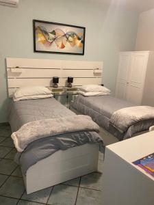 a room with two beds and a picture on the wall at La Casetta in Agrigento