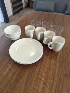 una mesa con platos blancos y tazas. en TOYA Center Village, en Lago Toya