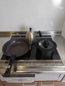a stove top with a pan and a tea pot on it at TOYA Center Village in Lake Toya
