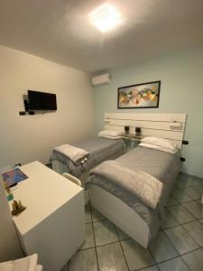 a room with two beds and a table and a tv at La Casetta in Agrigento