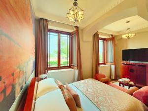 a room with a bed with a person reaching over it at Umaid Bhawan Palace Jodhpur in Jodhpur