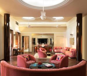 a living room with pink chairs and a couch at Umaid Bhawan Palace Jodhpur in Jodhpur