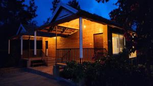 uma casa de madeira com um alpendre à noite em Coorg Bliss Estate Stay em Madikeri