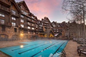 a large swimming pool in front of a building at Bachelor Gulch Ritz-carlton 1 Bedroom Mountain Residence With Ski In, Ski Out Access, Hot Tub, And Full Service Spa in Avon