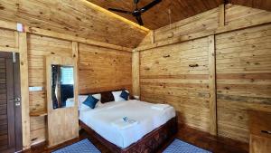 a bedroom with a bed in a wooden room at Coorg Bliss Estate Stay in Madikeri