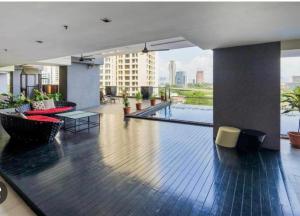 a hotel lobby with a pool and tables and chairs at MyHabitat - KLCC 2 bedroom in Kuala Lumpur