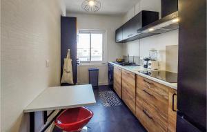 eine Küche mit einer Theke und einem roten Stuhl darin in der Unterkunft Cozy Apartment In Royan With Wifi in Royan