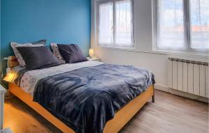 a bedroom with a bed with blue walls and windows at Cozy Apartment In Royan With Wifi in Royan