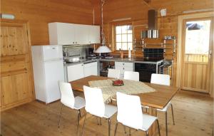 een keuken met een houten tafel en witte apparaten bij Gorgeous Home In Varaldsy With House Sea View in Skjelnes