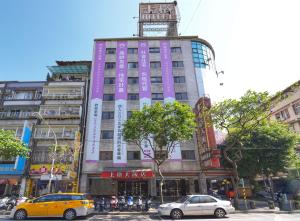 un edificio rosa con una torre de reloj encima en Shanger Hotel en Taipéi