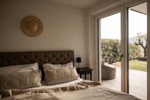 een slaapkamer met een bed en een glazen schuifdeur bij View House - Chalet Goyen in Schenna