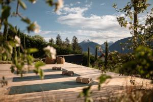 a wooden deck with logs on it with mountains in the background at View House - Chalet Goyen in Schenna