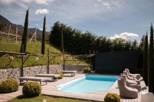 uma piscina num quintal com bancos e uma televisão em View House - Chalet Goyen em Schenna