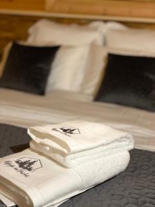 two white towels sitting on top of a bed at Chalet Le Montagnard SPA & SAUNA - Lits faits - Serviettes - Peignoirs - Ménage inclus in Rochesson +22 photos