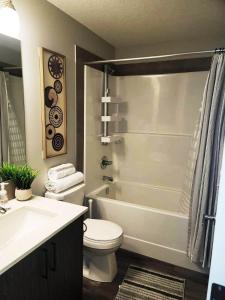 a bathroom with a toilet and a sink and a shower at Cozy Springs in Calgary