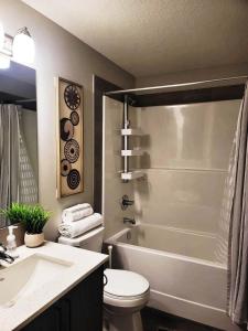 a bathroom with a toilet and a sink and a shower at Cozy Springs in Calgary