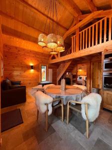 a dining room with a table and chairs in a cabin at Chalet Le Montagnard SPA & SAUNA - Lits faits - Serviettes - Peignoirs - Ménage inclus in Rochesson