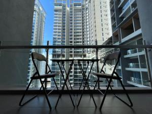 a table and two chairs on a balcony with a view of buildings at Atlantis Residence Batik Travel in Tranquerah