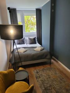 um pequeno quarto com uma cama e uma janela em Apartament Verde em Toruń