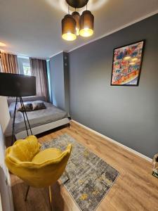 um quarto com uma cadeira amarela e uma cama em Apartament Verde em Toruń