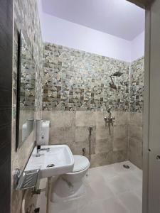 een badkamer met een toilet, een wastafel en een douche bij Hotel Grand Mala in Jaipur