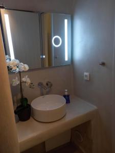 a bathroom with a sink and a mirror on a counter at Cueva House in Vóthon