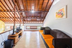 sala de estar con sofá y TV en Villa Padma by Best Deals Asia Hospitality, en Nusa Dua