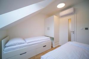 Habitación blanca con 2 camas y escalera en Chata Lipno U Hajenky en Lipno nad Vltavou