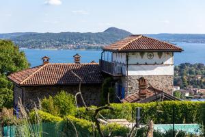 a building on top of a hill next to the water at La TORRETTA Studios & Suite in Lesa