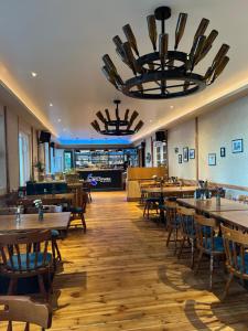 a restaurant with wooden tables and chairs and a large chandelier at Seeblick Apartment am Mellensee in Mellensee