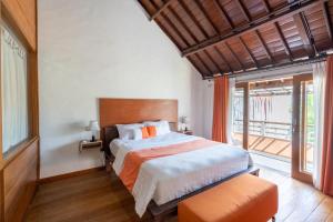 a bedroom with a bed and a large window at Villa Padma by Best Deals Asia Hospitality in Nusa Dua