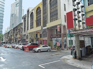 吉隆坡的住宿－Super OYO 90780 J Hotel Bukit Bintang，一条城市街道,汽车停在建筑前
