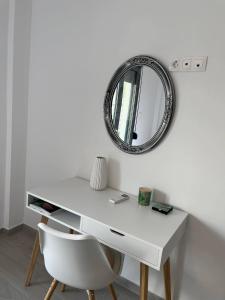 - un bureau blanc avec une chaise et un miroir dans l'établissement Tiffany's apartments -2' walk from Metro, à Athènes