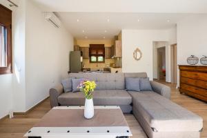 ein Wohnzimmer mit einem Sofa und einem Tisch in der Unterkunft Villa Estrella in Ägina Stadt