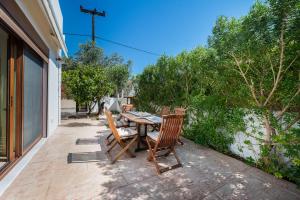 una mesa de madera y 2 sillas en el patio en Villa Estrella, en Aegina Town