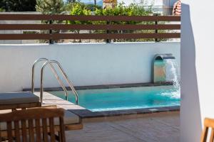 - une piscine avec une fontaine dans un bâtiment dans l'établissement Villa Estrella, à Égine