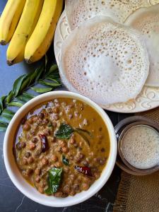 a bowl of soup and a plate of bread and bananas at Kurianplackal Residency in Alwaye
