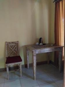 - une table en bois et une chaise dans la chambre dans l'établissement Biorock Dive Support, à Pemuteran