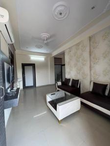 een woonkamer met een bank en een salontafel bij Hotel Grand Mala in Jaipur