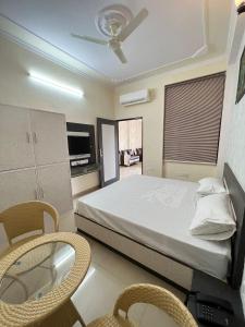 een slaapkamer met een bed en een tafel en stoelen bij Hotel Grand Mala in Jaipur