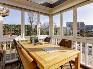comedor con mesa de madera y ventanas en Beautiful holiday home in Kropswolde with private terrace, en Kropswolde